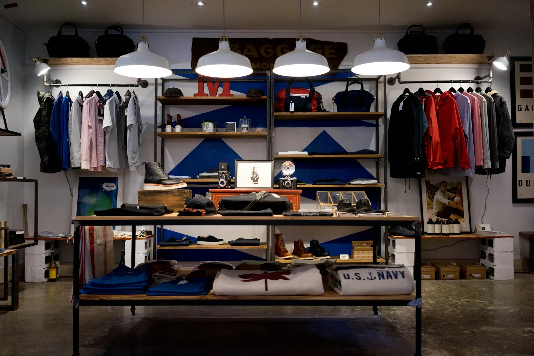 Interior de un local de ropa con estantes y mesa de productos
